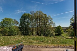 Un espace extérieur agréable, avec une terrasse en bois, des arbres et un ciel dégagé.