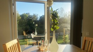 Ein Esstisch mit Blumen, Weingläsern und Kerzen.