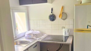 Une cuisine compacte équipée d’un lave-linge, d’une cuisinière et d’un réfrigérateur.