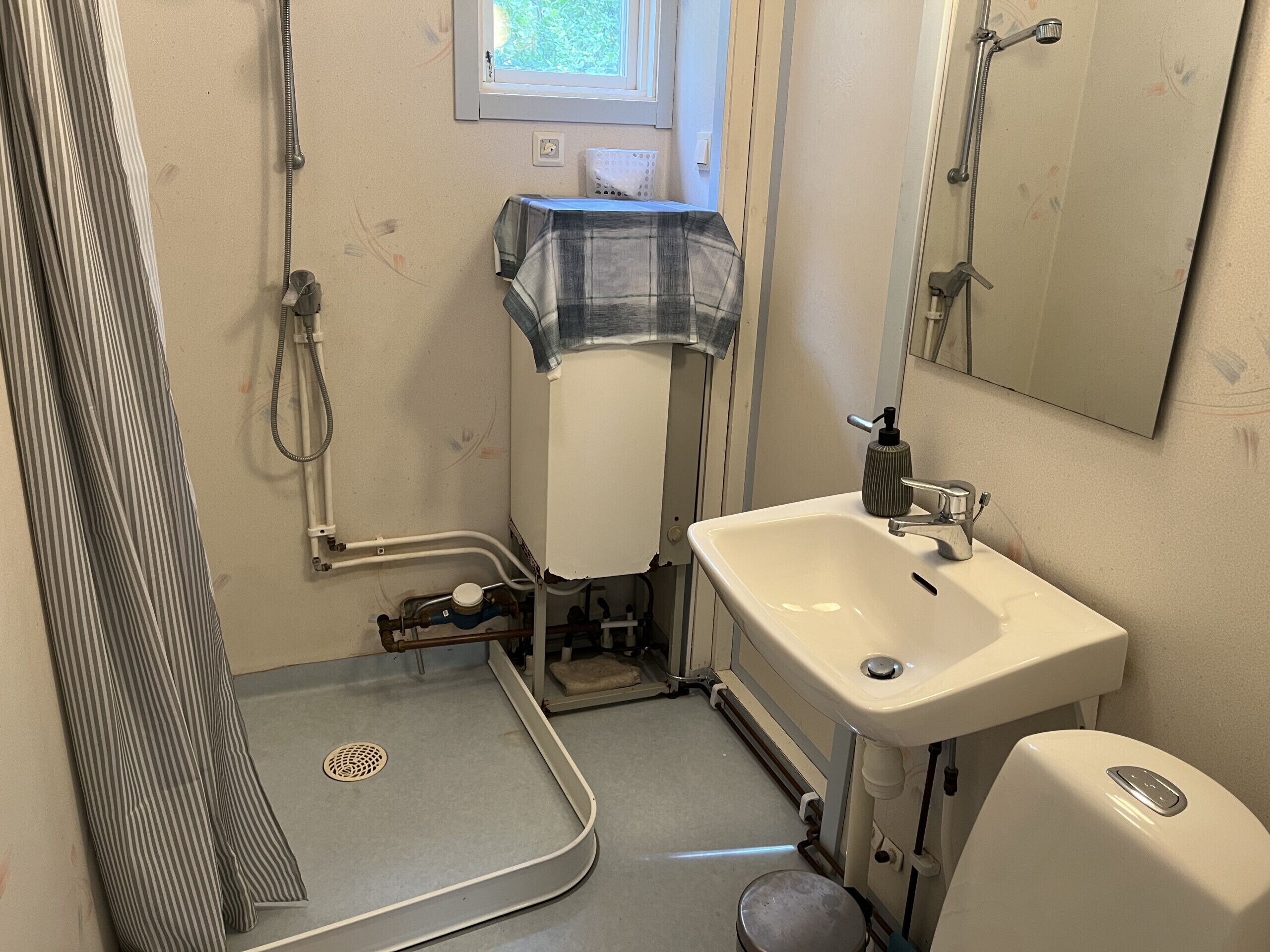 Een badkamer met een douche, wastafel en toilet.