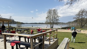 A lakeside deck with picnic tables and a playground.