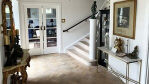 A grand staircase with a chandelier, a mirror, and a statue. - Magnificent, spacious villa located in the middle of Vimmerby in SE05056 (Vimmerby)