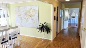 A hallway with a map on the wall, a plant, and a dining area with chairs. - Large and spacious villa located in Storebro close to a nice swimming area | SE05059 (Storebro)