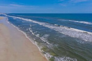 Uma praia com ondas suaves a beijar a costa.