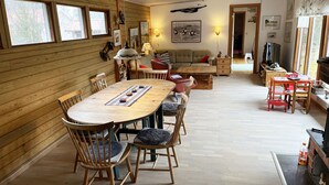 Un interior acogedor de madera con una mesa de comedor, sillas y un sofá.