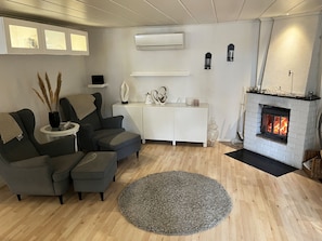 En stue med pejs, sofa, sofabord og et tæppe.