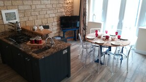 A modern kitchen with granite countertops, a built-in stove, and a dining area with a round table and chairs.