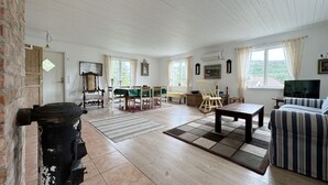 Amplia sala de estar con comedor, chimenea y televisor.