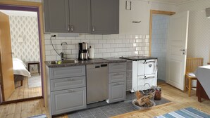 A compact kitchen with grey cabinets, a coffee maker, and a small sink.