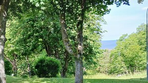 A grassy area with trees and a view of the sea. - Modern apartment in the center of Visby | SE12053 (Visby)