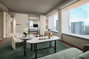 A modern hotel room with a dining area, a sofa, a TV, and a large window with a city view. - Fairmont Xiamen  (Xiamen)