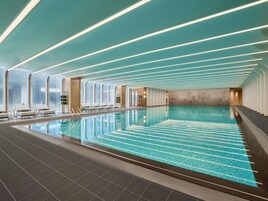 Una piscina interior con suelo de baldosas y una zona de natación larga y estrecha.