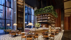 A modern interior with a central bar area, seating arrangements, and large windows. - Fairmont Xiamen  (Xiamen)