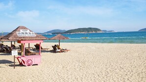 A beach with a service station, beach chairs, and umbrellas. - Grand Mercure Sanya Yalong Bay  (Sanya)