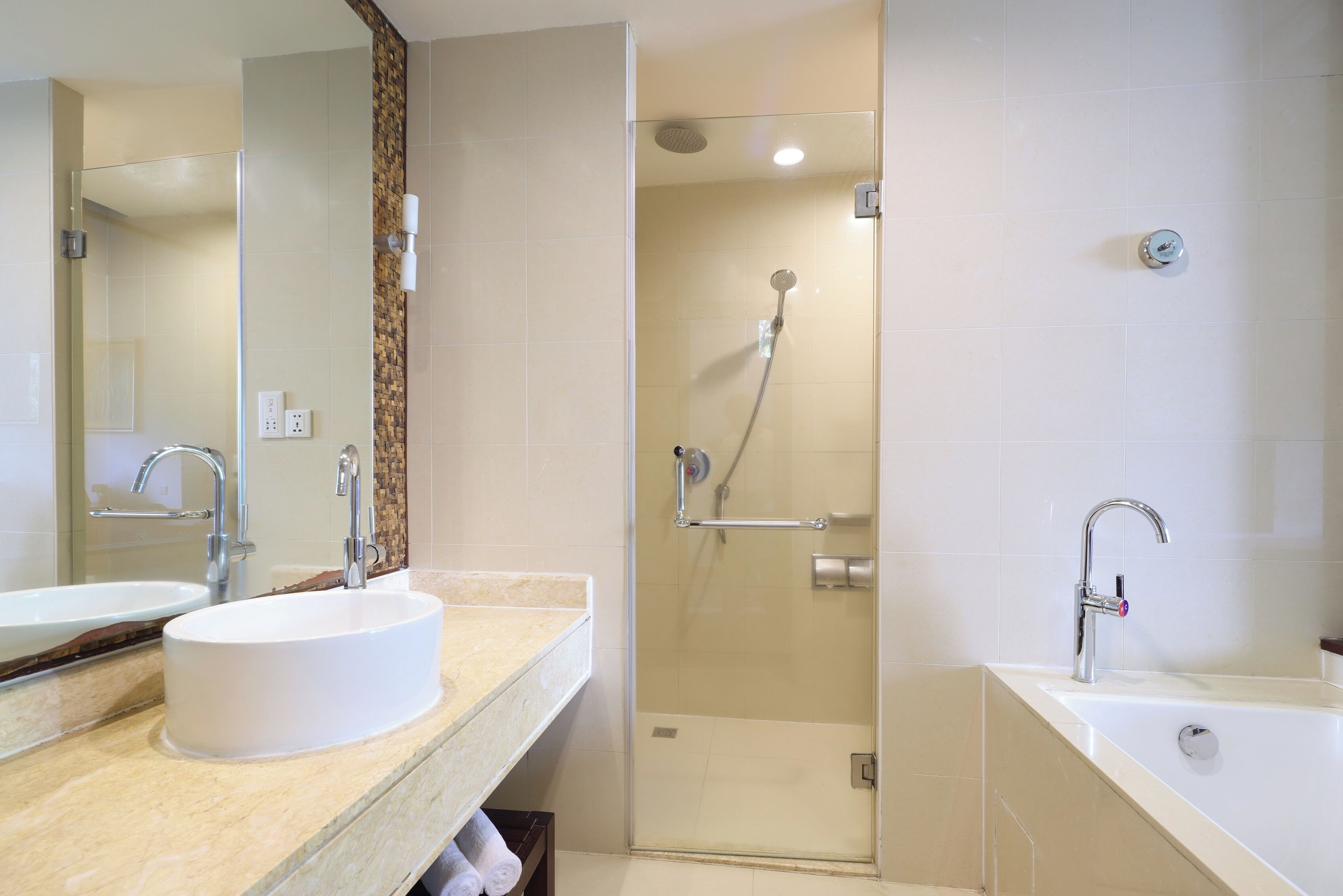 A modern bathroom with a large mirror, a sink, a shower, and a bathtub.