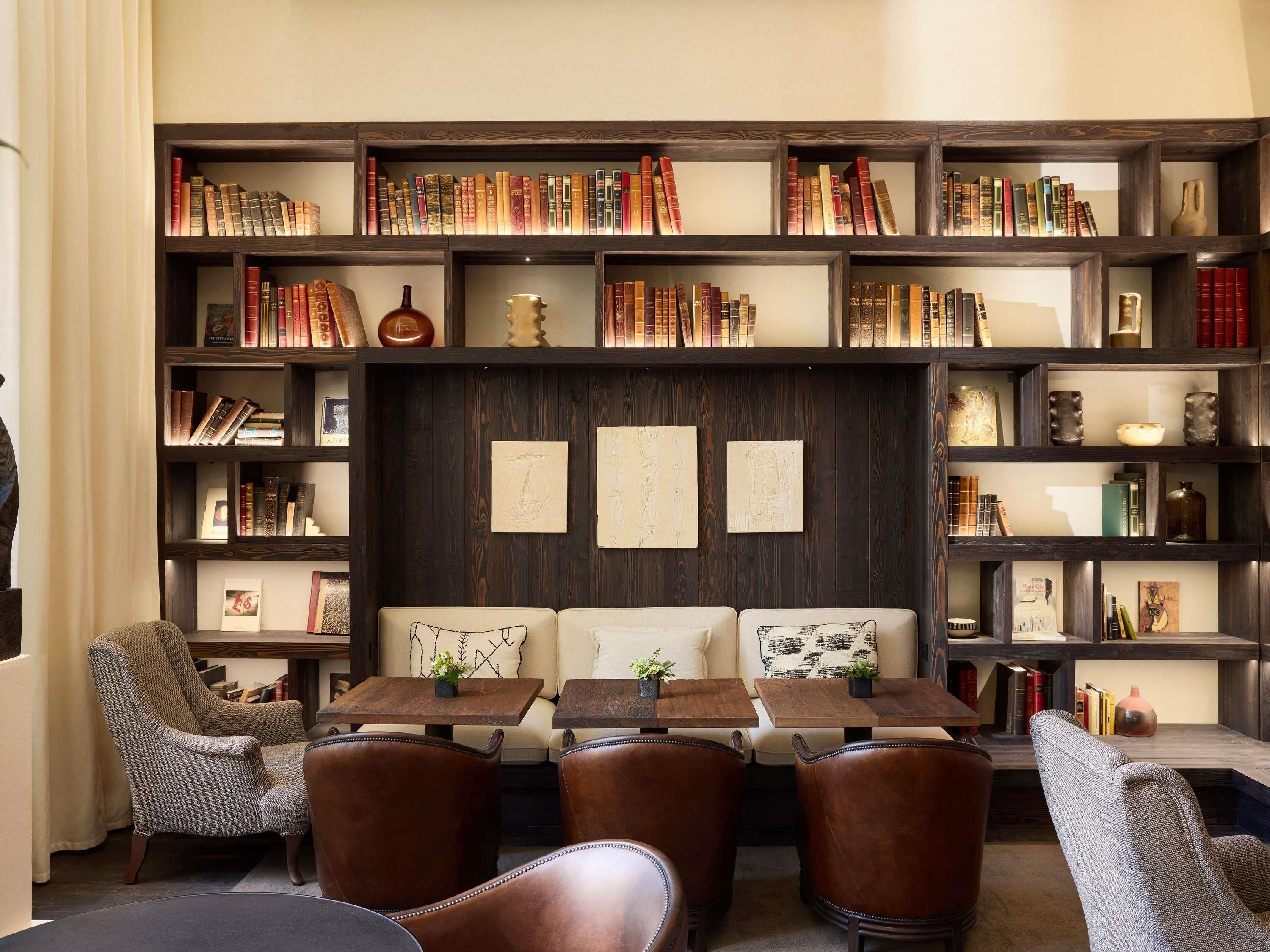 A library with bookshelves, a sofa, and two tables.