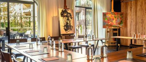 A conference room with a long table, chairs, and glass decanters.