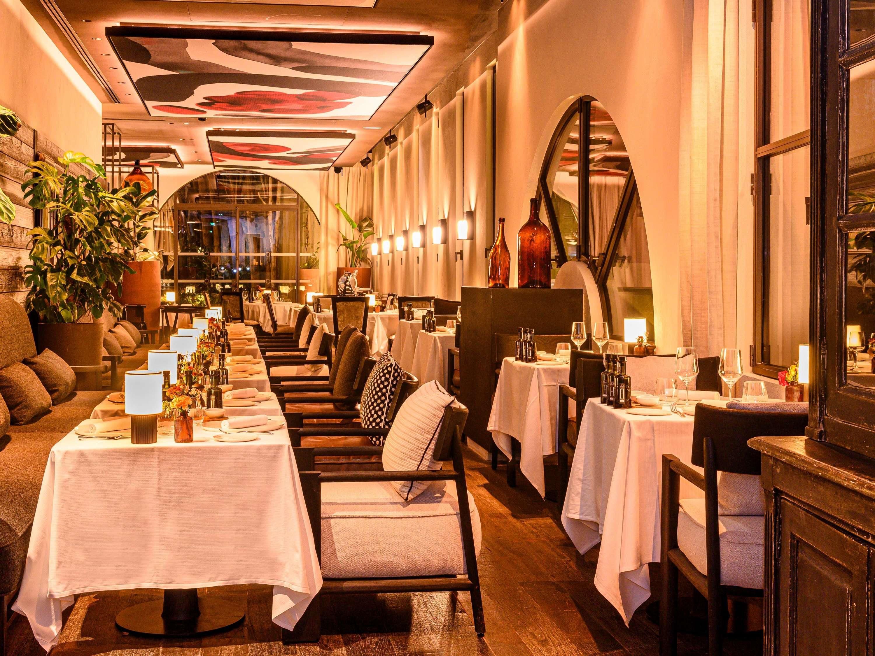 Un restaurant avec de longues tables, des chaises et une ambiance chaleureuse et accueillante.