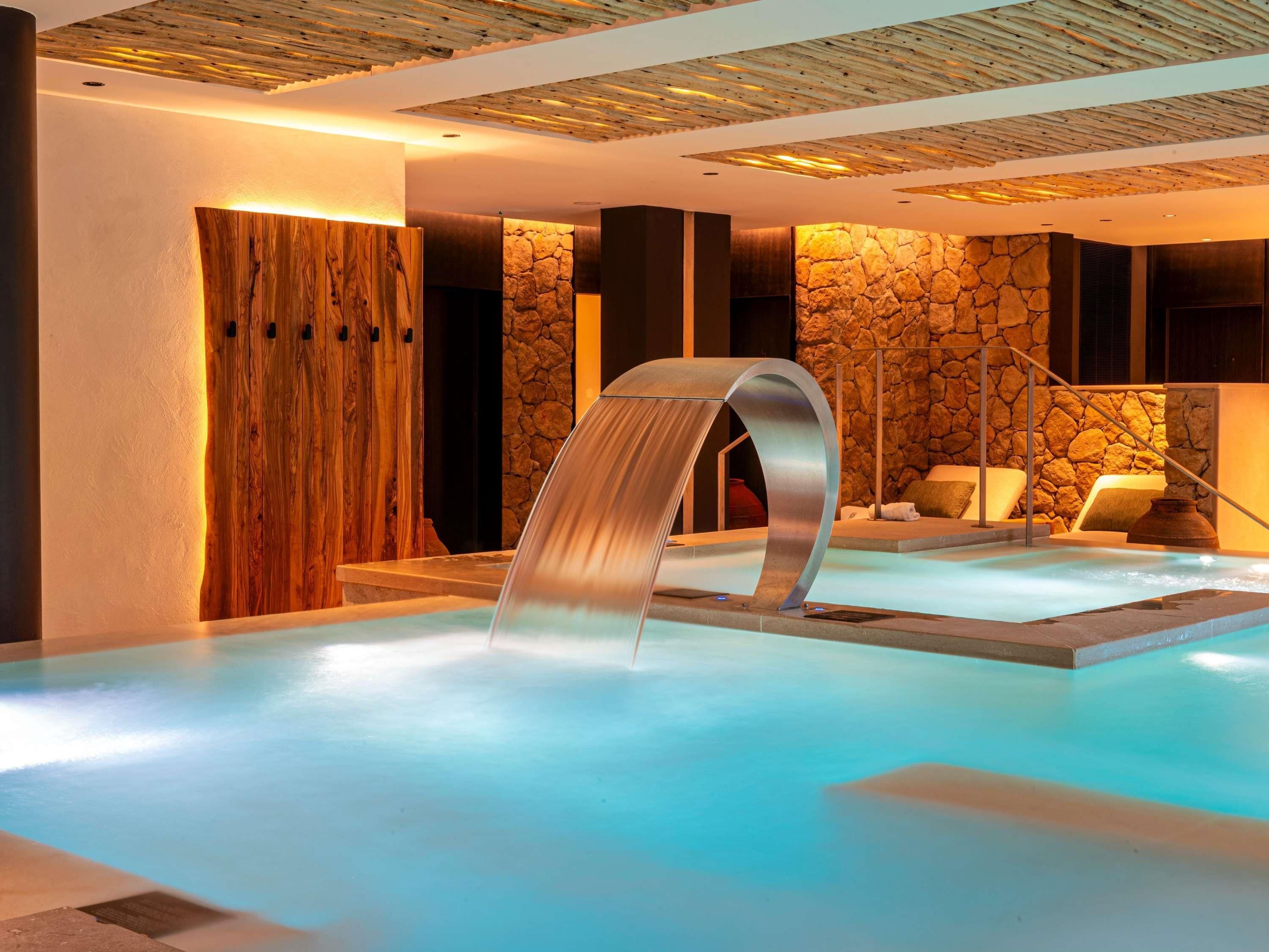 Un área de spa con un jacuzzi, una pared de madera y una pared de piedra.