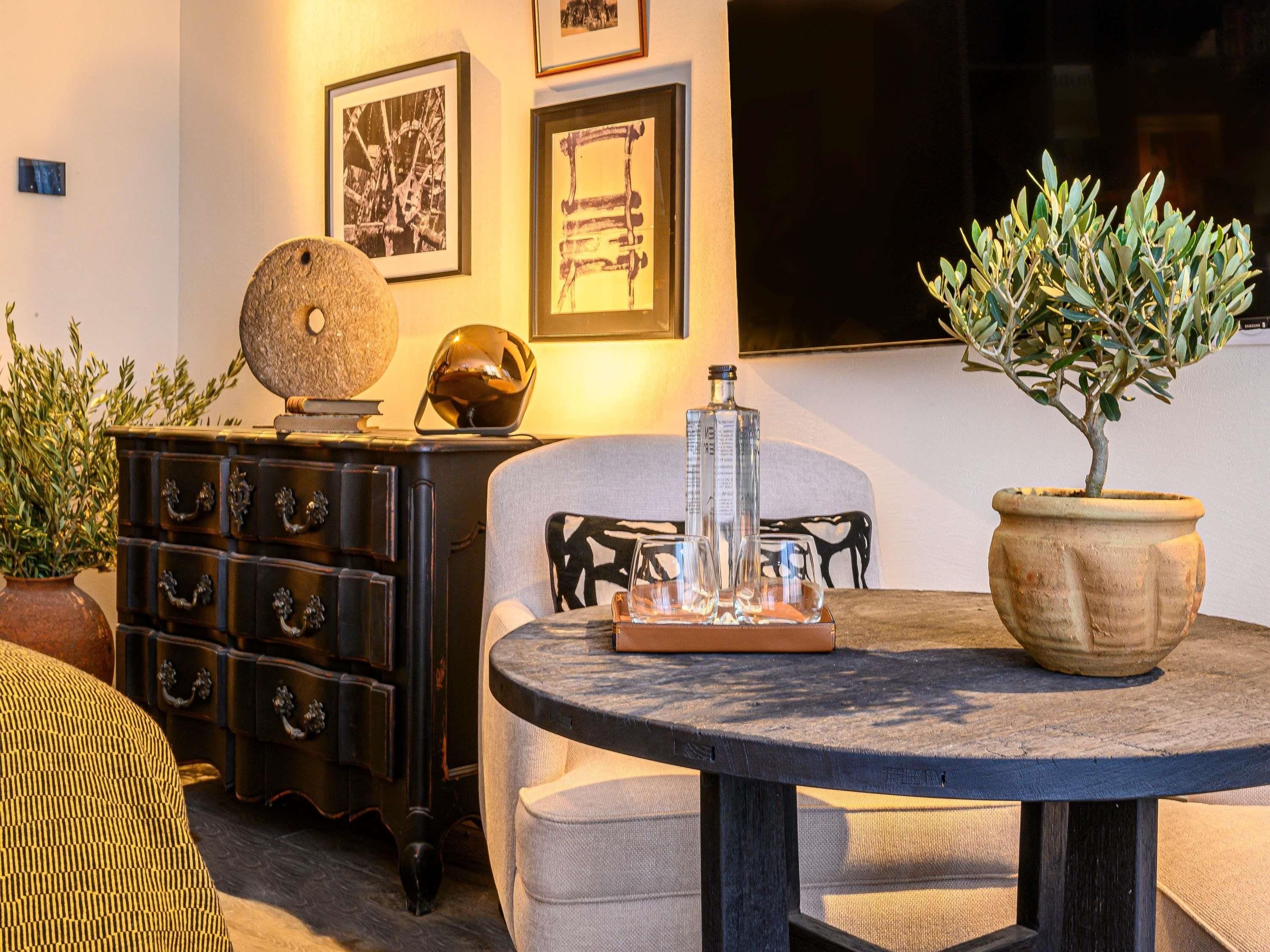 Un salon chaleureux avec une table ronde, un canapé, un globe décoratif et une plante en pot.