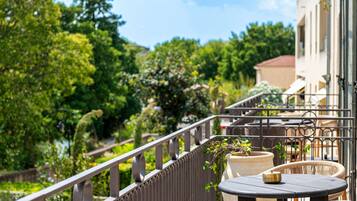 Suite Junior, 1 Tempat Tidur King, balkon, pemandangan kolam renang | Seprai premium, isi minibar gratis, brankas, dan tirai kedap cahaya