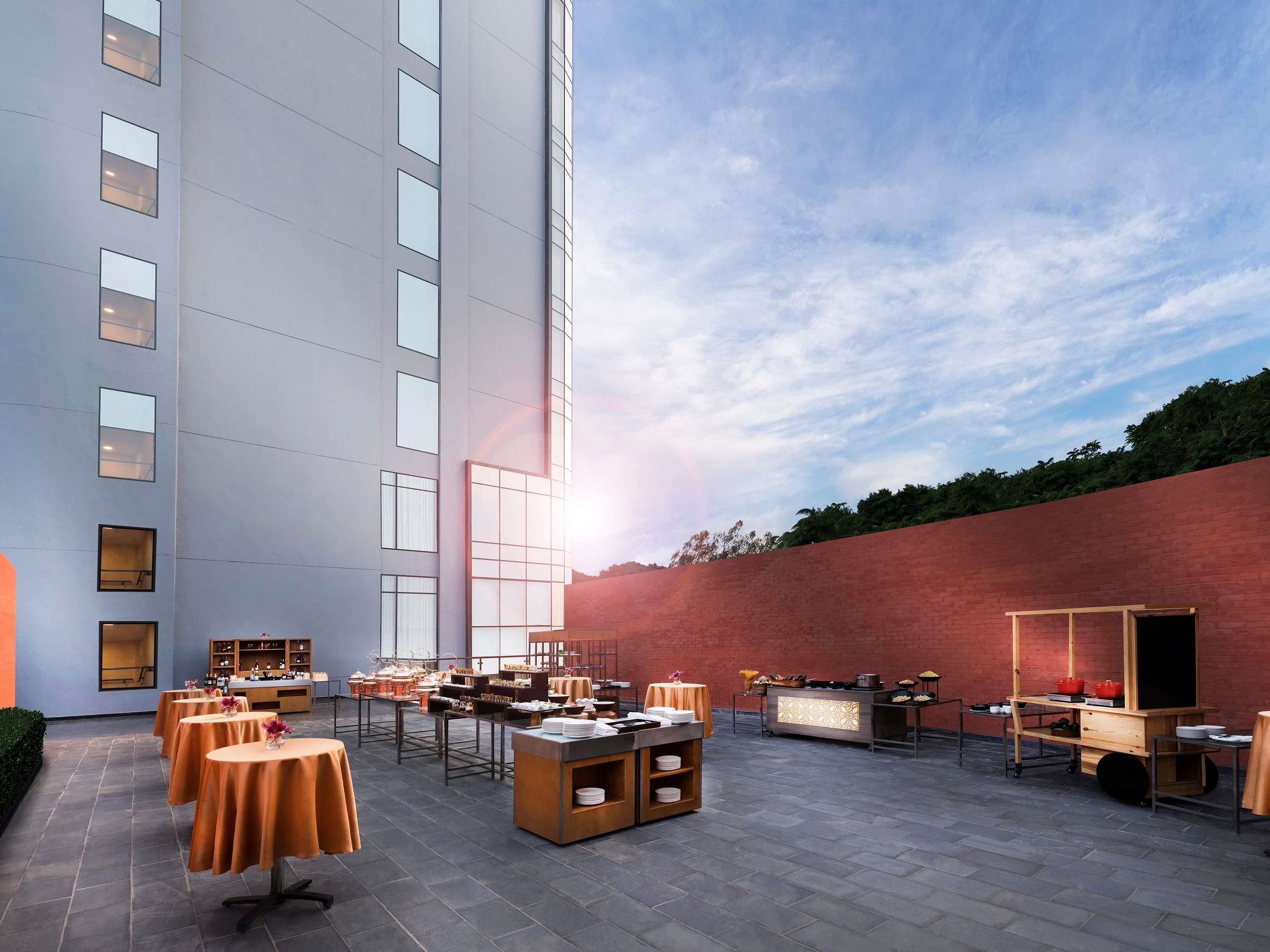 A rooftop dining area with tables, a buffet, and a brick wall.