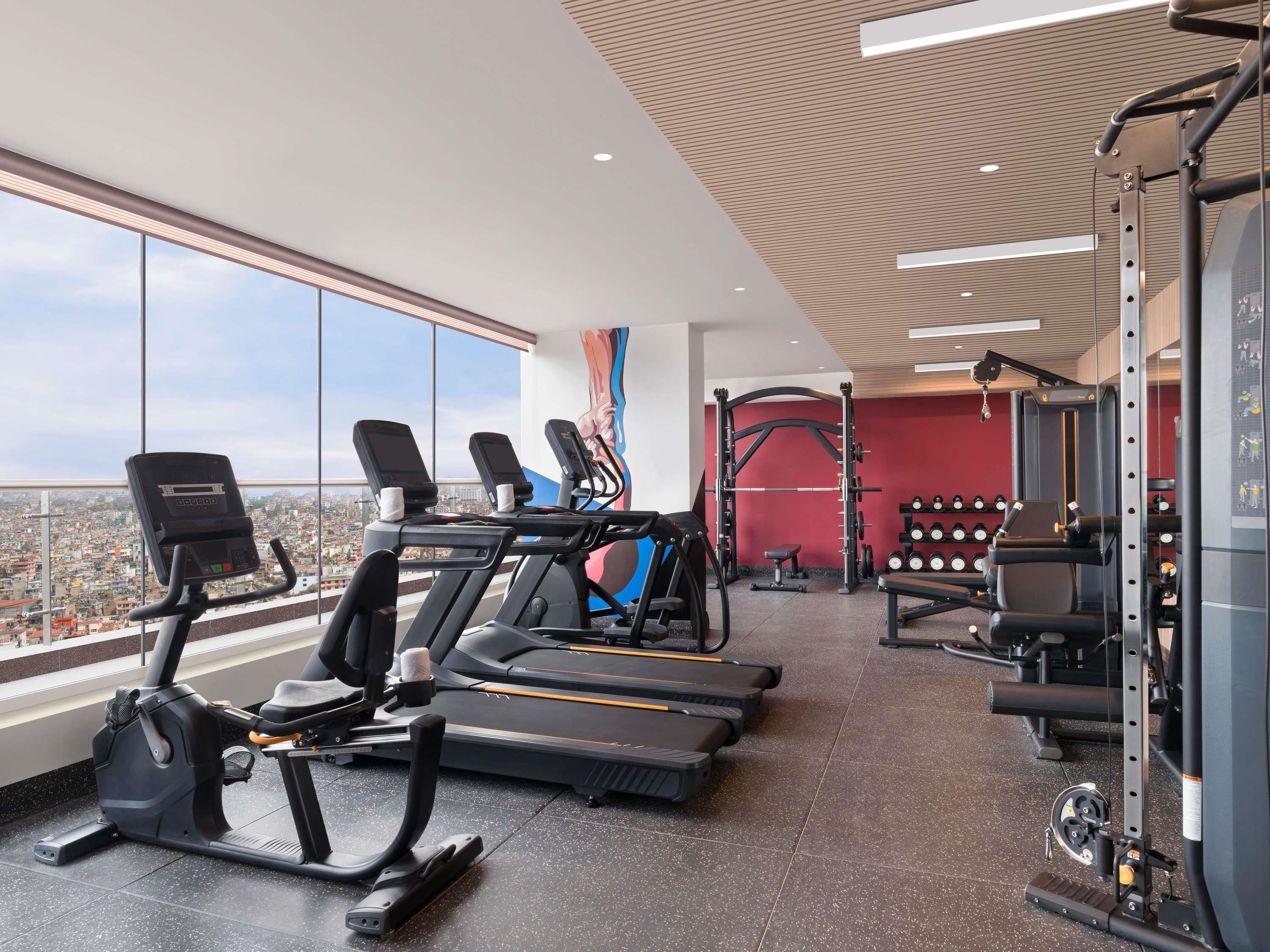 Una palestra con tapis roulant, rack per squat e bilancieri.