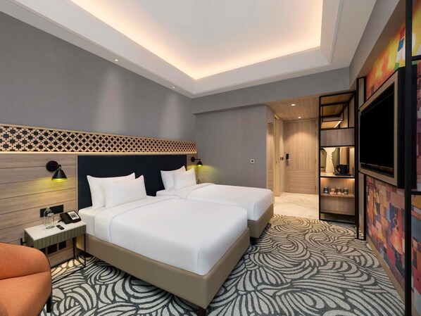 A hotel room with a large bed, two bedside tables, a desk, a chair, a TV, and a wardrobe. - Mercure Kathmandu Sukedhara Heights (Kathmandu)