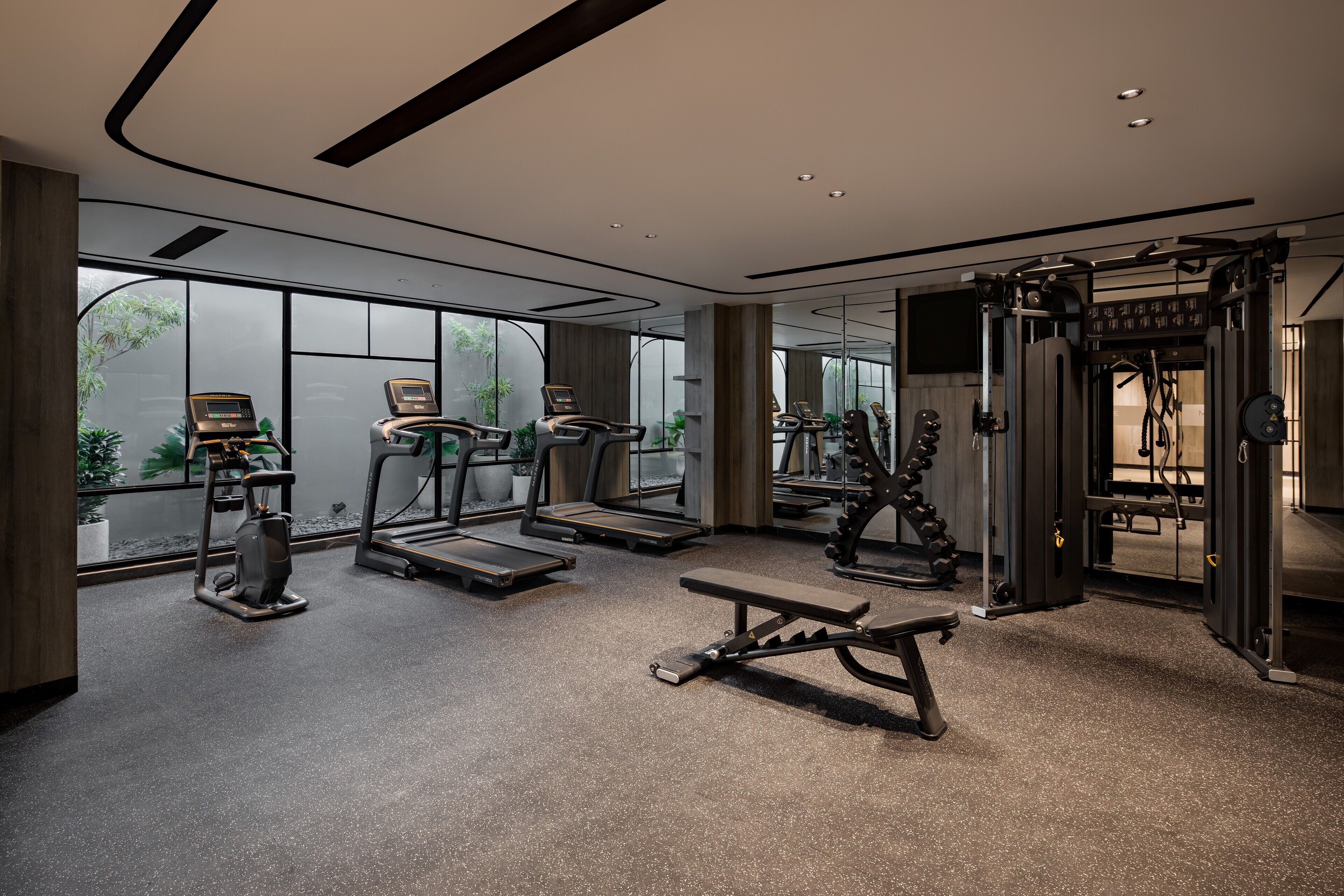 Una palestra moderna dotata di tapis roulant, panca per pesi e macchinari per allenamento con i pesi.