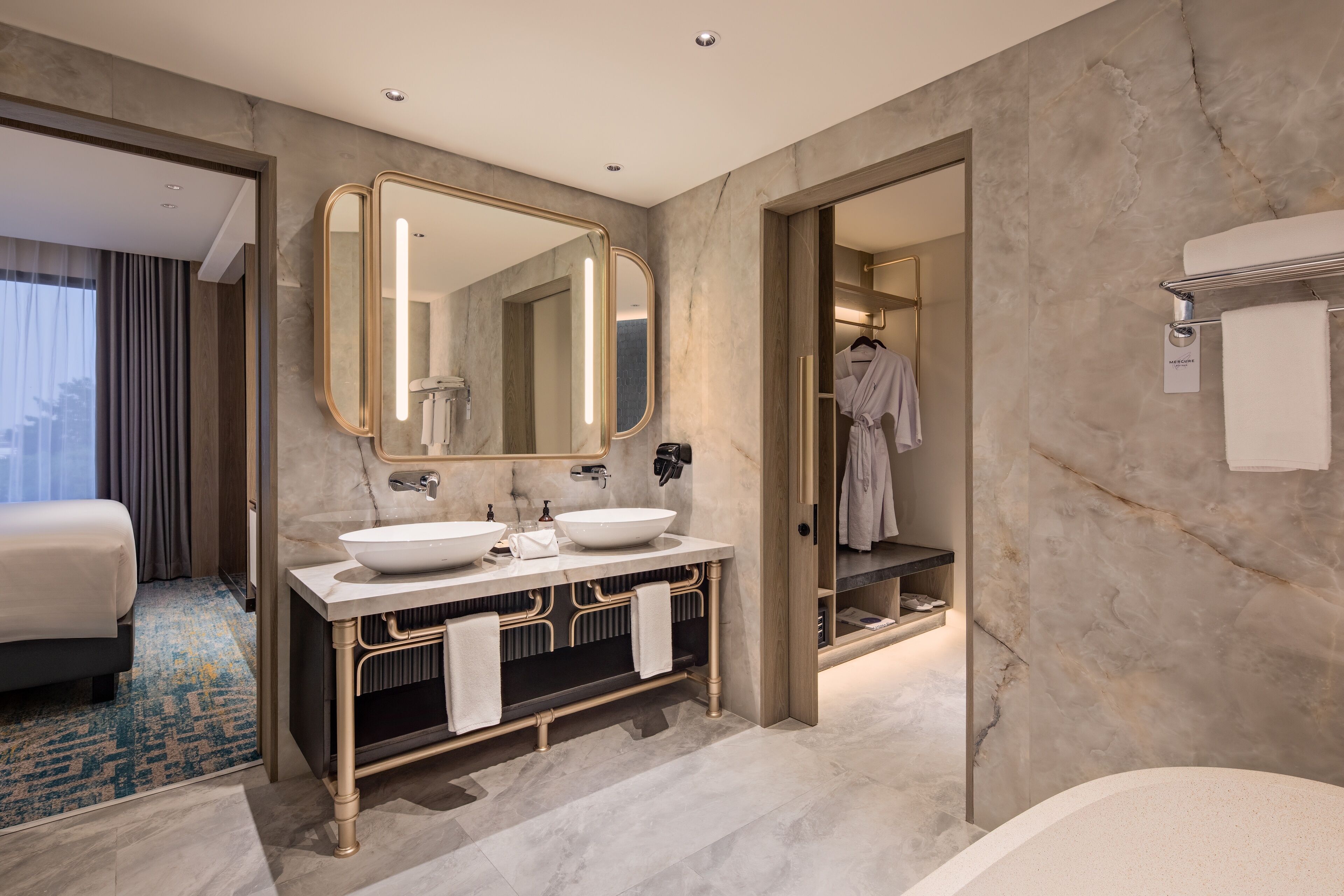 Un baño moderno con dos lavamanos, un espejo grande y una bañera.