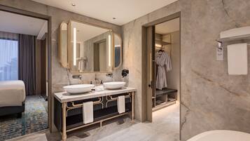 Un baño moderno con dos lavamanos, un espejo grande y una bañera.