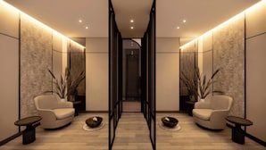 A modern, minimalist lobby with two sofas, a central walkway, and decorative plants. - Mercure Madiun (Madiun)