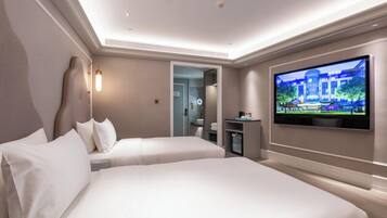 Habitación de hotel con dos camas, televisión y minibar.