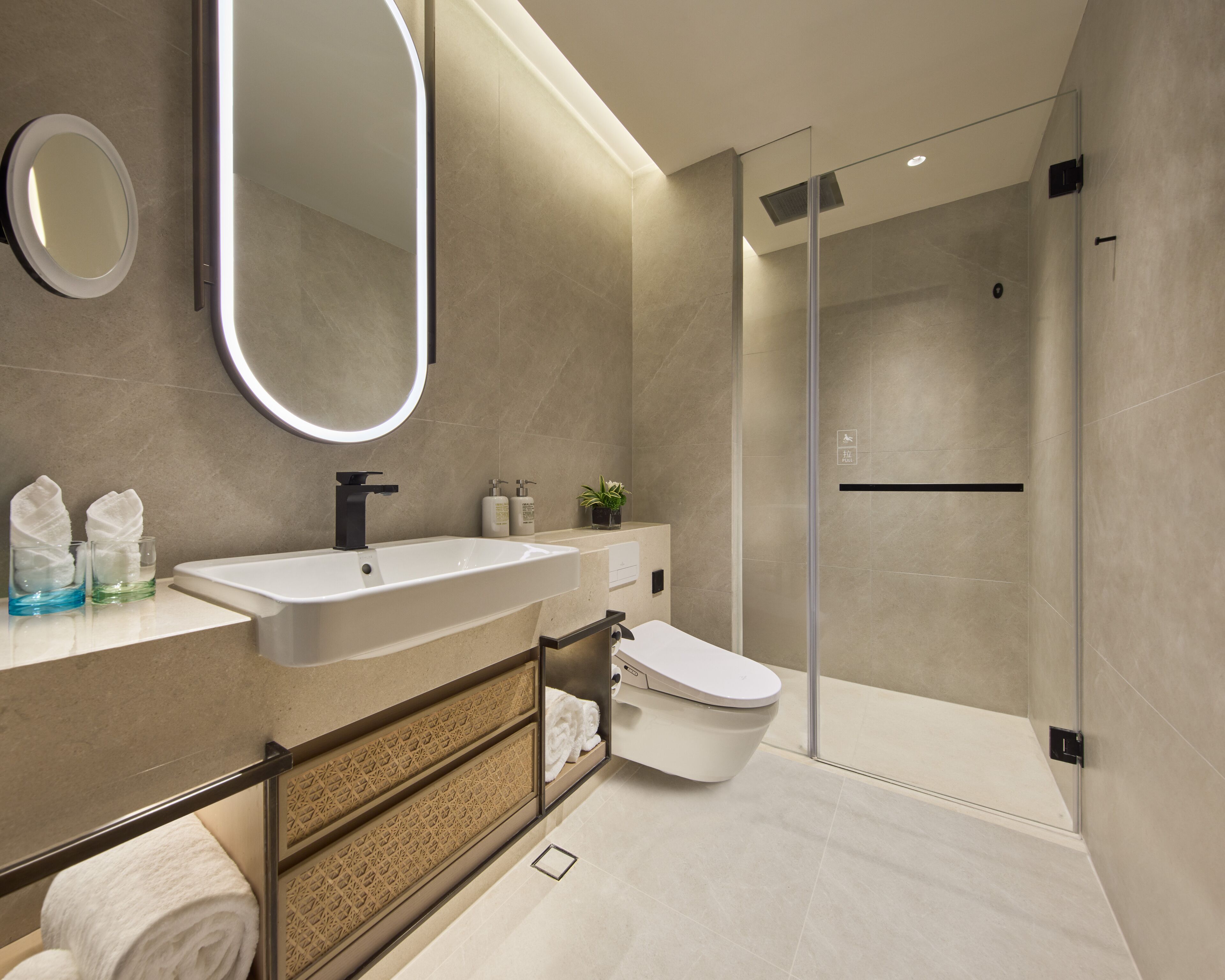 A modern bathroom with a large sink, mirror, and toilet.