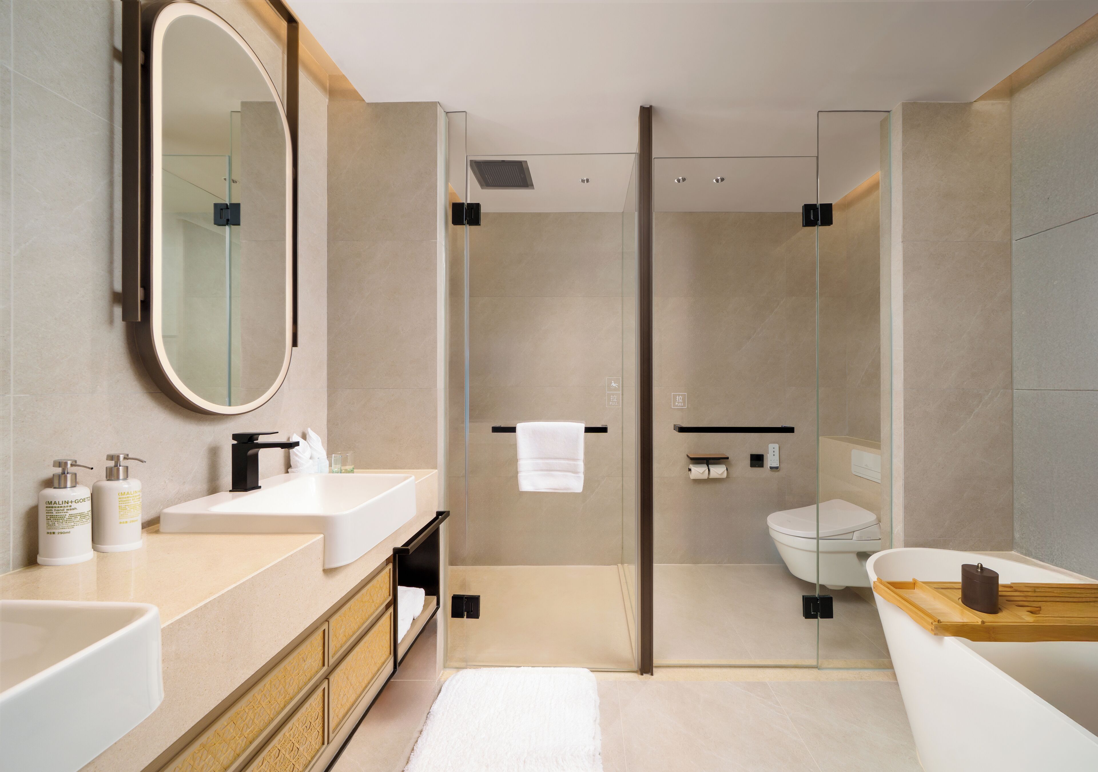A modern bathroom with a glass-enclosed shower, a white sink, and a bathtub.