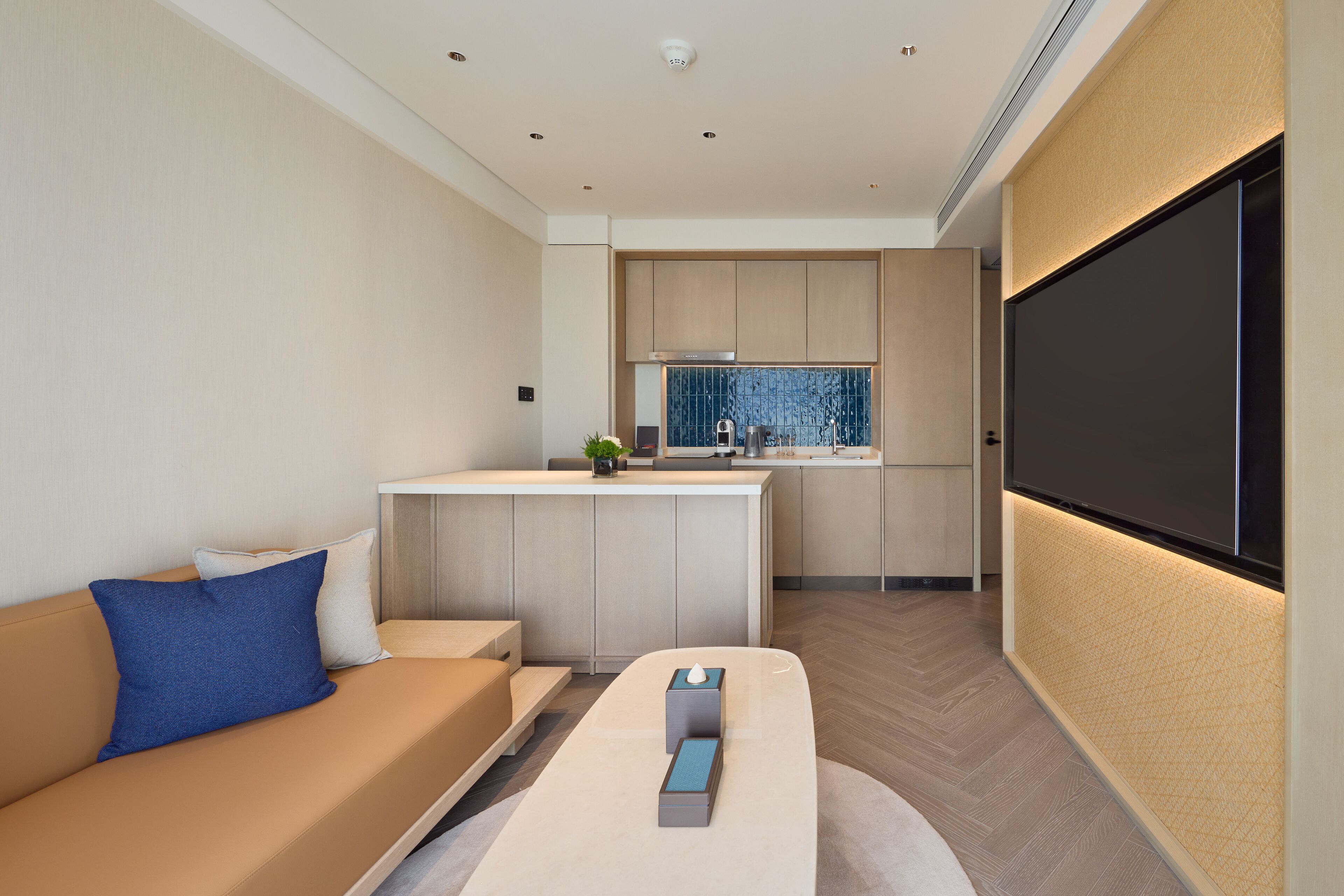 A modern living room with a sofa, a coffee table, and a TV wall.