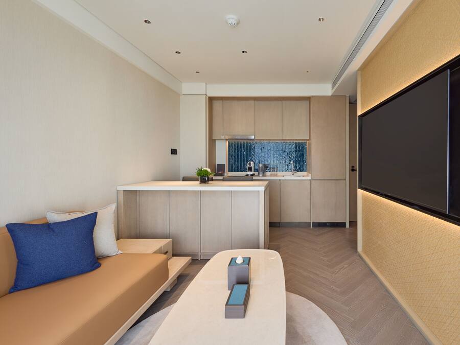 Un salon moderne avec un canapé, une table basse et un mur dédié à la télévision.