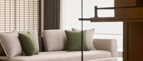 A modern living room with a sofa, a coffee table, and a decorative screen.