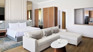 A modern hotel room with a large bed, a sofa, a small table, and a wardrobe. - Mövenpick Hotel Waad Al Shamal (Turaif)
