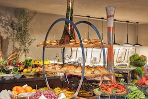 A buffet with various food items and a decorative centerpiece. - Novotel Istanbul Bomonti (Istanbul)