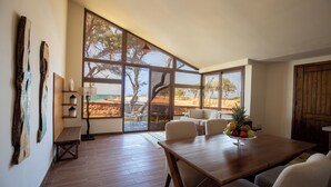A spacious room with large windows, a wooden dining table, and a view of the outdoors. - Rixos Montaza Alexandria (Alexandria)