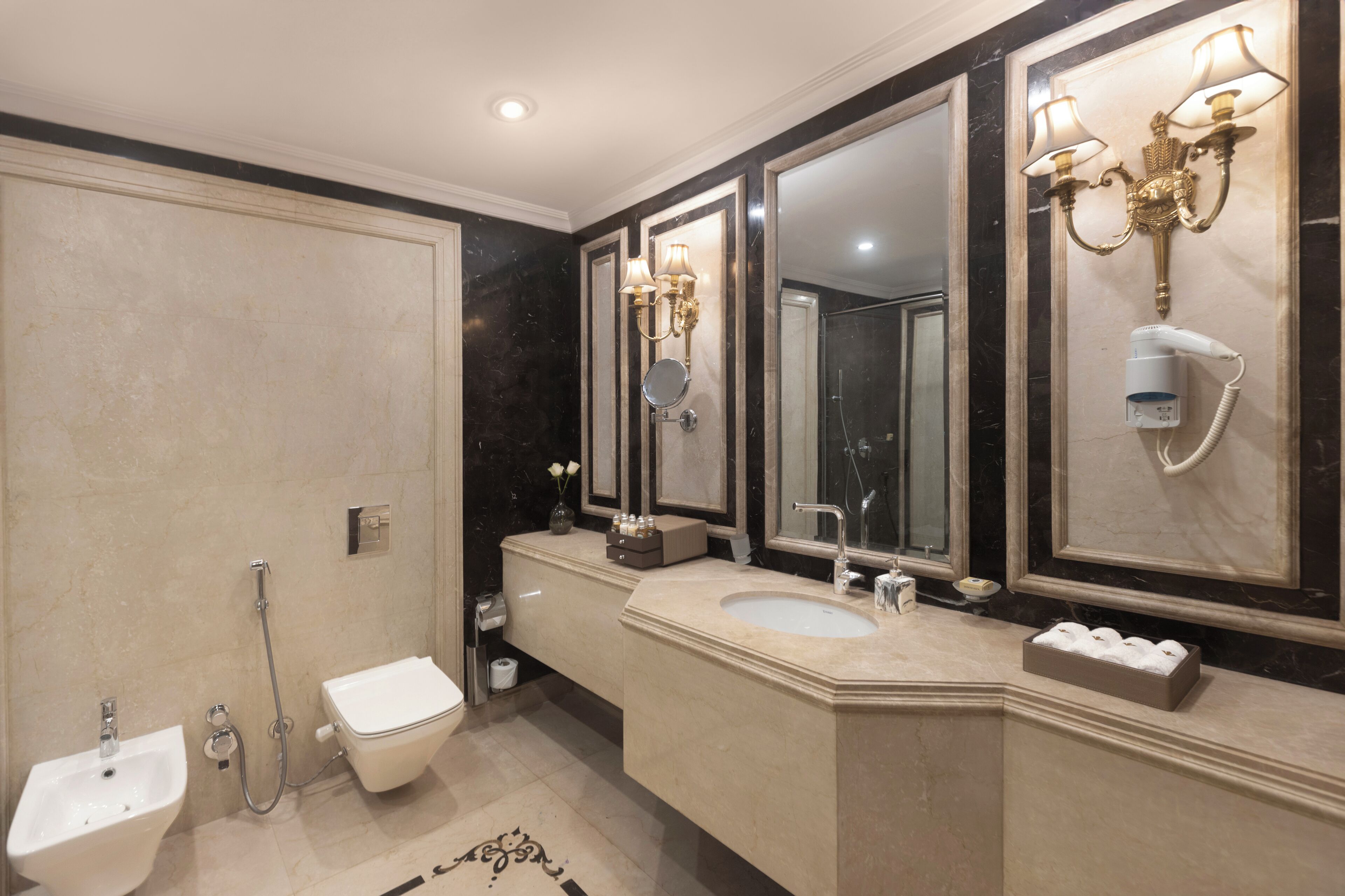 A modern bathroom with a bidet, a toilet, a sink, and a large mirror.