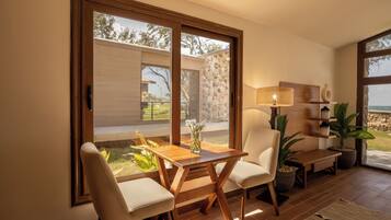 Una sala de estar moderna con una mesa y sillas de madera, ventanas grandes y vistas al exterior.