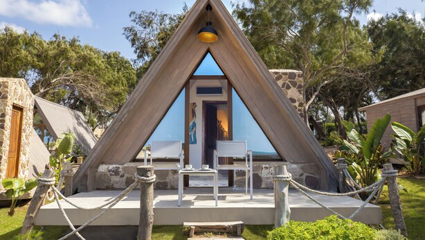 A triangular wooden structure with a door, seating area, and rope barrier. - Rixos Montaza Alexandria (Alexandria)