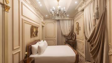 Um quarto luxuoso com uma cama grande, decorações de parede elaboradas e um candelabro.