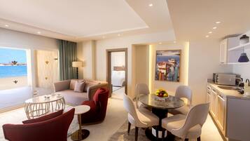 Une chambre d’hôtel moderne dotée d’un espace de vie, d’un coin repas et d’une cuisine.