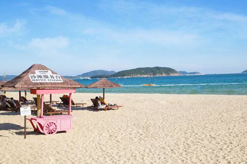 Vlak bij het strand, wit zand, ligstoelen, parasols