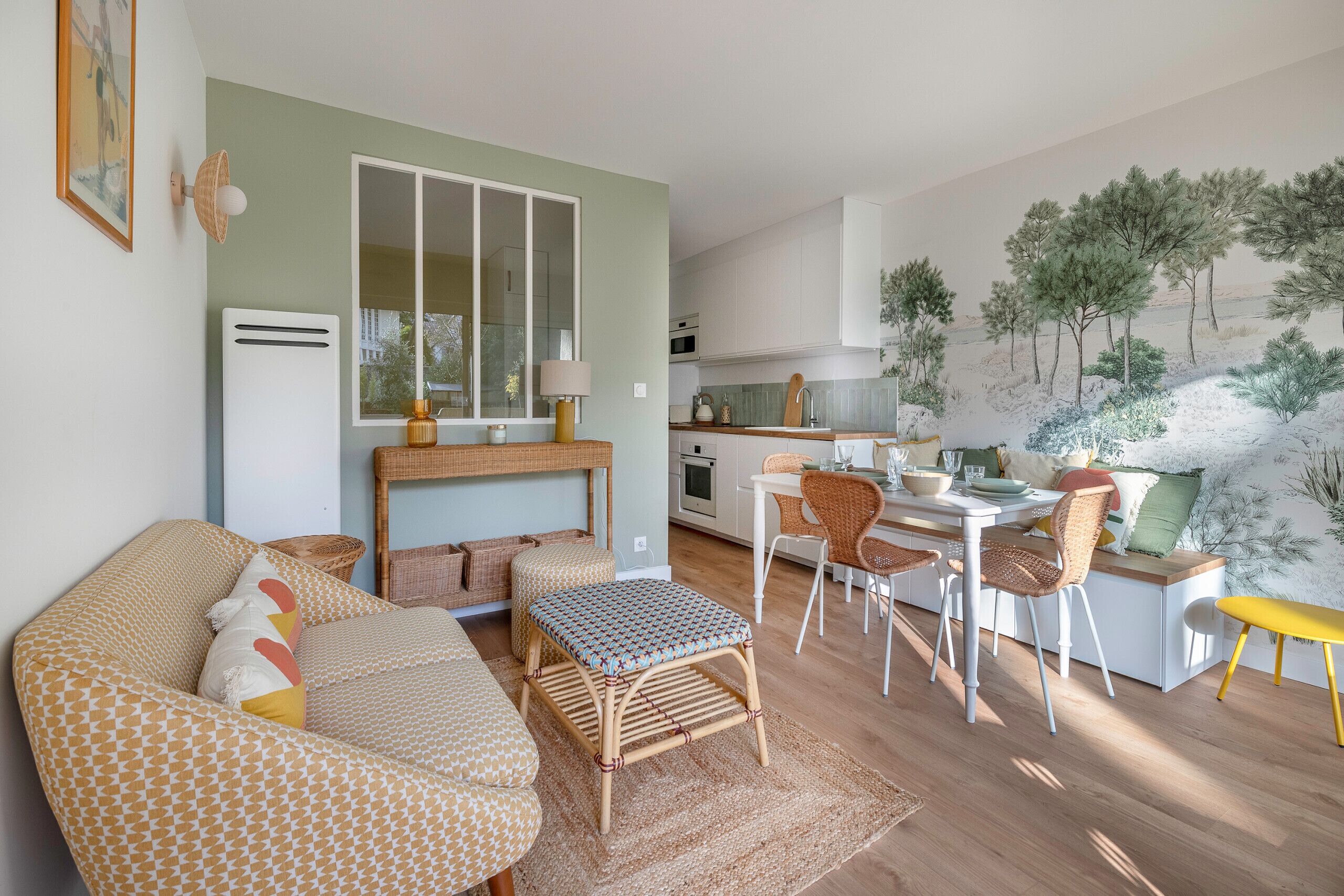 A cozy living room with a sofa, ottoman, and dining area with chairs and a table.