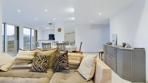 A modern living room with a sofa, dining area, and kitchen. - 350m from the beach, house for 7 with a pool (Bretignolles-sur-Mer)