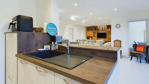 A modern kitchen with a built-in sink, a coffee machine, and a sign for 'hoomy' service. - 350m from the beach, house for 7 with a pool (Bretignolles-sur-Mer)